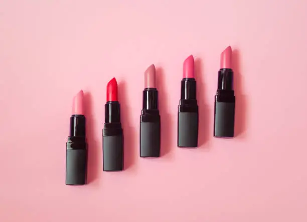 Photo of Set of beautiful lipsticks on pink background.