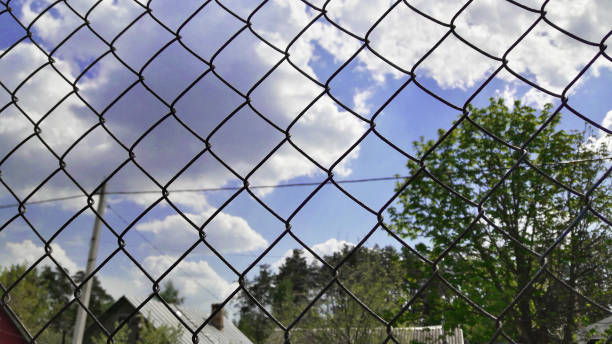 istock blue sky and clouds behind a metal grid 1151794459