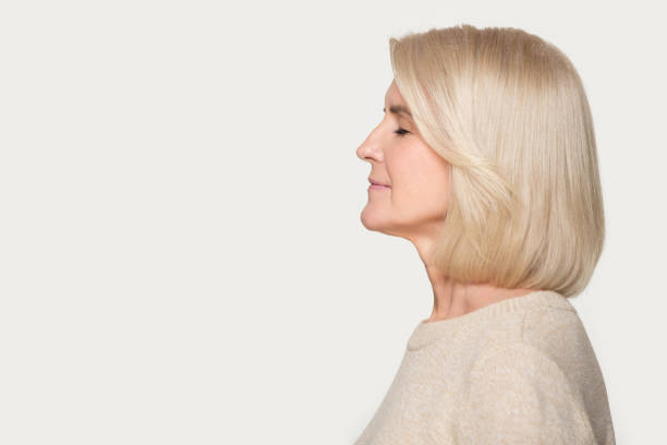 istock Profile view aged woman standing aside on grey studio background 1151796032