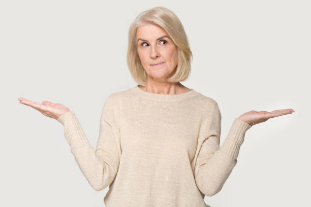 Mature woman stretched hands thinking makes choice on white background