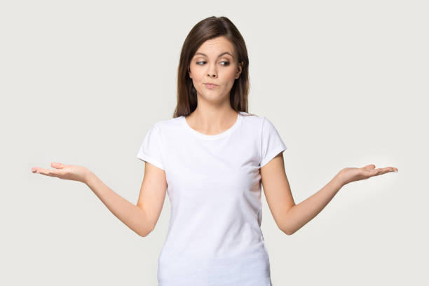 istock Millennial woman stretched hands thinking makes choice on grey background 1151796103