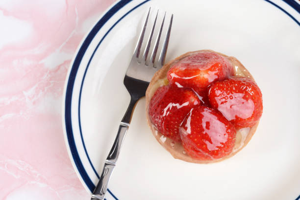 top view strawberry custard glazed tart with a fork