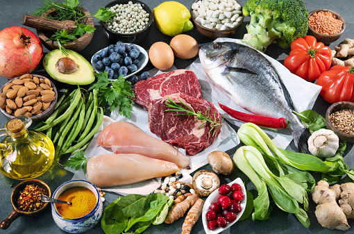 Balanced diet food background. Selection of various paleo diet products for healthy nutrition. Superfoods, meat, fish, legumes, nuts, seeds, greens and vegetables
