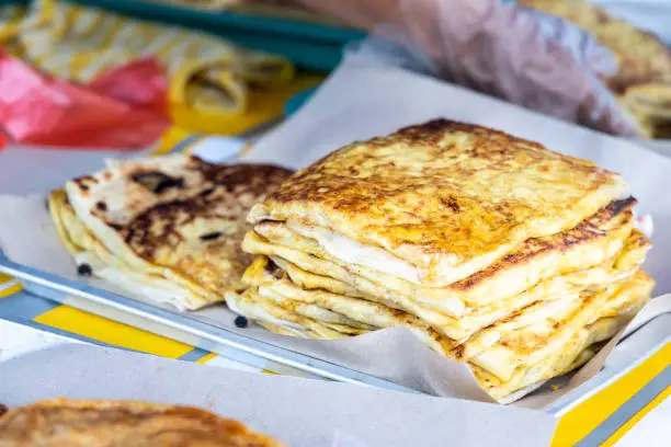 Photo of Seller preparing murtabak at street stall for iftar during Ramadan.