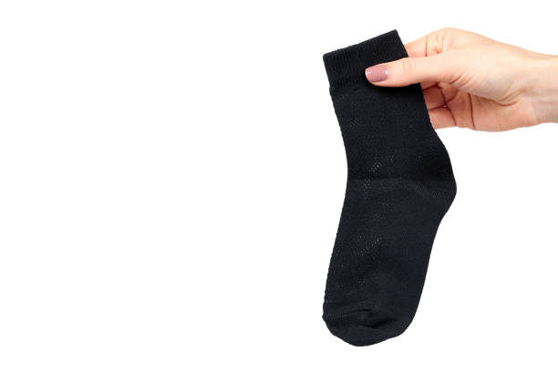 istock Hand with black cotton sock, foot clothing. 1151801309