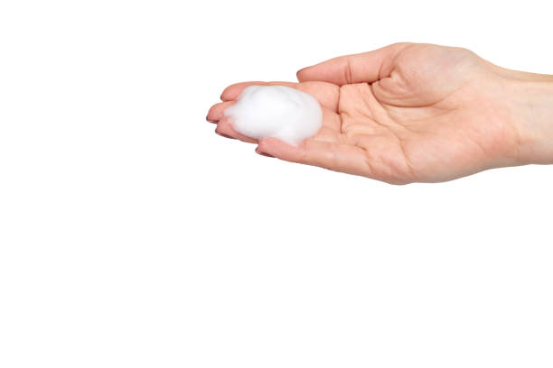istock Hand with white foam bubbles, beauty smooth mousse, close up photo. 1151801887