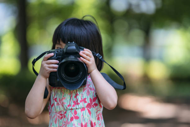 petite fille mignonne prenant des photos dans la nature - child blank expression pensive focus on foreground photos et images de collection