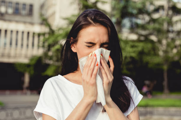 spring allergies and sneezing a young woman in the park has a cough and allergy sneezeweed stock pictures, royalty-free photos & images