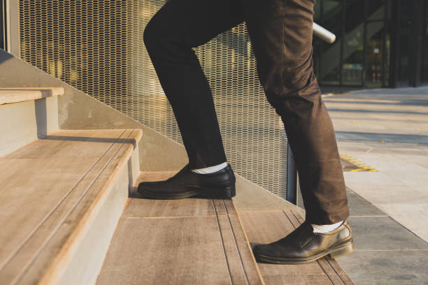istock Businessman legs walking up the stairs 1151808159