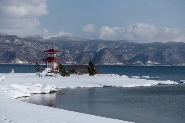 Lake Toya with island and Japanese building, fresh snow in mid-winter