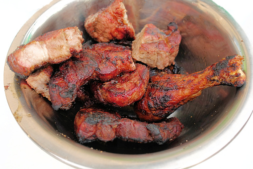 Meat cooked on fire in an iron plate close-up.
