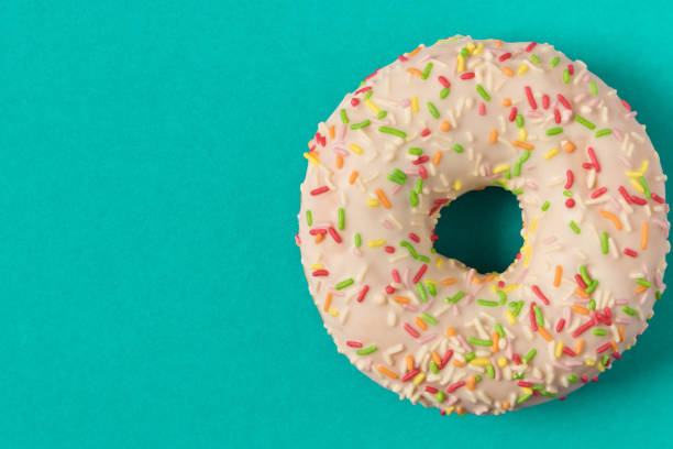 istock Fresh glazed donut with colorful sprinkles on a blue background. 1151814264