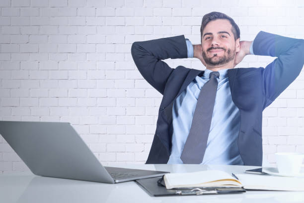 istock Relaxed businessman at table, brick wall 1151816488