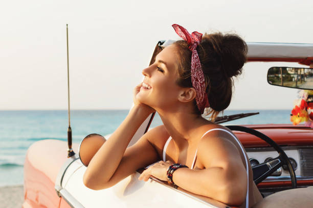 Beautiful and happy woman inside retro cabriolet car