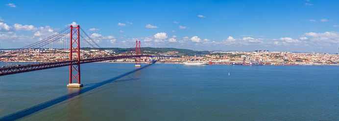 Lisbon, Portugal. Ponte 25 de Abril Suspension Bridge with Lisbon in background. Connects the cities of Lisbon and Almada over the Tagus River.