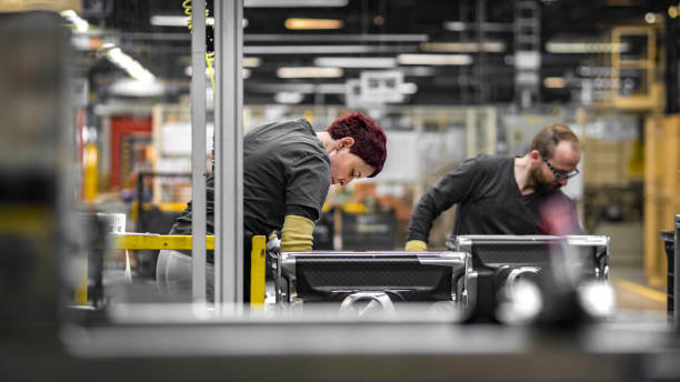 Two factory workers assembling an appliance in a factory.