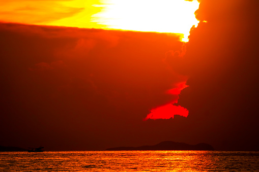 sunrise on silhouette cloud and ray colorful sky fishing boat and on sea island background