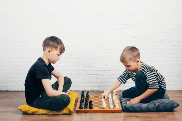 istock Two boys playing chess at home on the floor. 1151833023