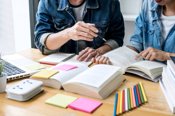 istock Education, teaching, learning, technology and people concept. Two high school students or classmates with helps friend do homeworks learning in classroom, Tutor books with friends 1151837540