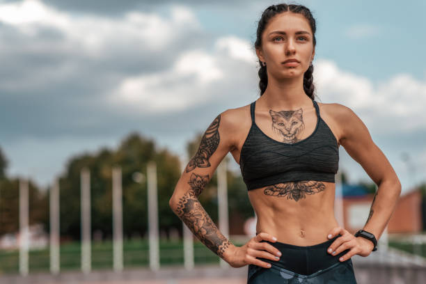 woman sports coach, summer city, fitness workout. motivation strength mind thoughts. tattoo cats on figure. smart bracelet, watch. free space. beautiful girl in morning on the run. - headphones women tattoo music imagens e fotografias de stock