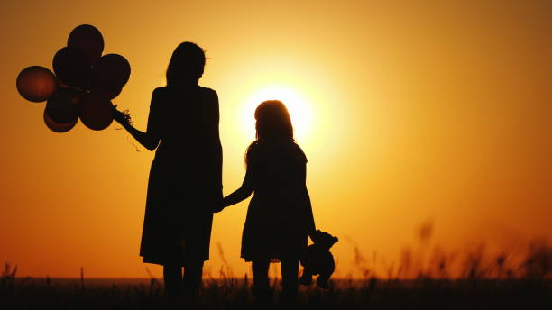 istock Mom with dock stand at sunset. Keep balls and toy bear 1151840247