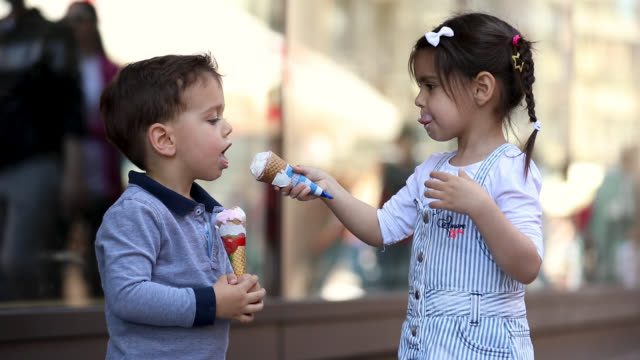 Cute Kids Sharing Ice Cream In Front Of Shopping Mall
