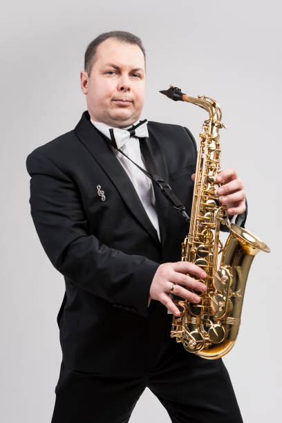 istock Relaxing Caucasian Man Posing With Saxophone Against White Background. Vertical Image 1151844074