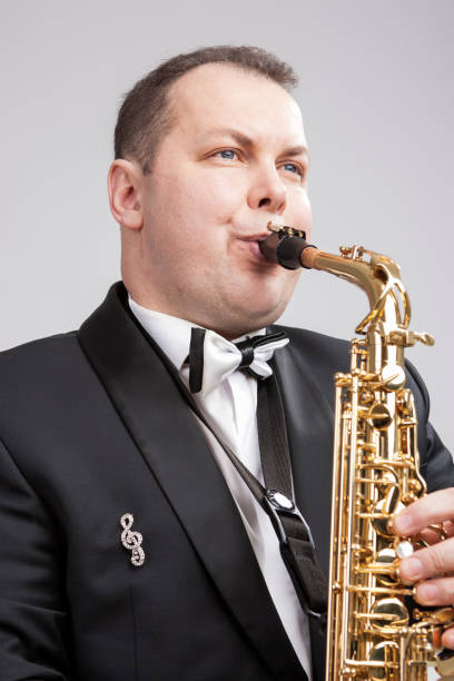 istock Portrait of Caucasian Player in Suit Playing on Saxophone.Vertical Image Composition 1151844186