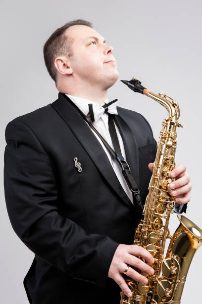 istock Relaxing Caucasian Man Posing With Saxophone Against White Background. Vertical Image Orientation 1151844189