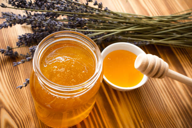 istock Lavender honey in jar and honey dipper. 1151846588