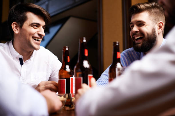 istock Laughing adult men having beer together 1151847611