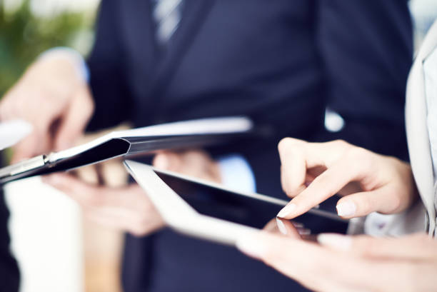 istock Crop businesswoman using tablet with colleagues 1151848900