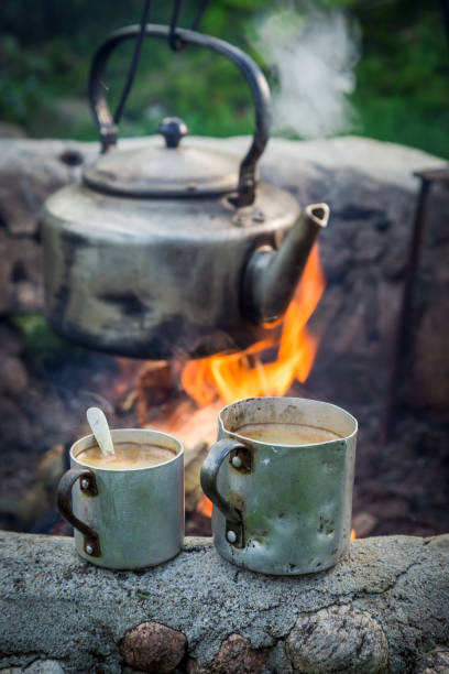 istock Hot coffee on rocks with kettle on campfire 1151849189