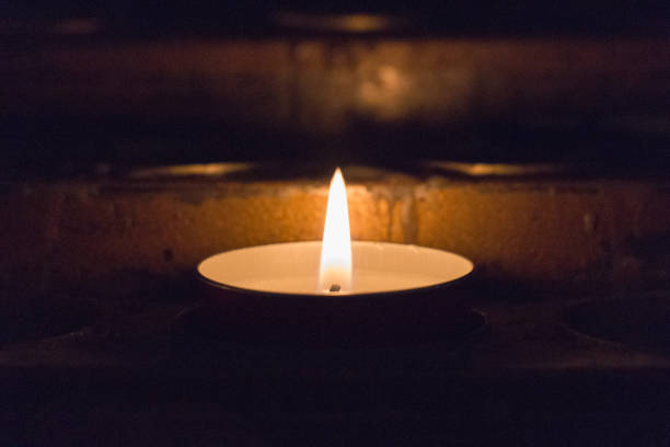 istock Close up of lighted tealight candle. Burning candle. 1151851640