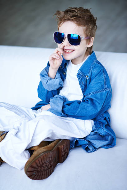 istock Adorable boy in sunglasses picking nose 1151853583