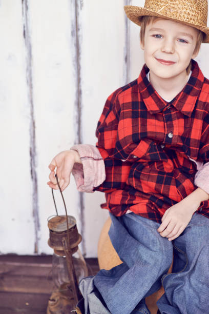 istock Smiling boy in big plaid shirt holding lantern 1151853668