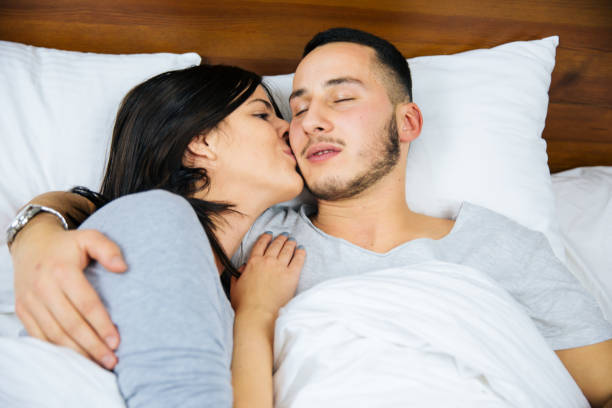 istock Young couple in bed embracing. 1151856368
