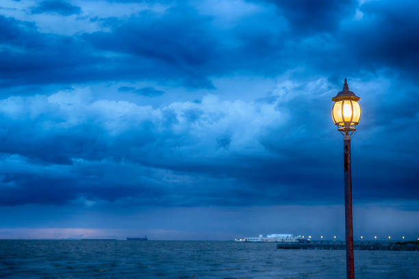 Light Post at nigth near sea with stom background