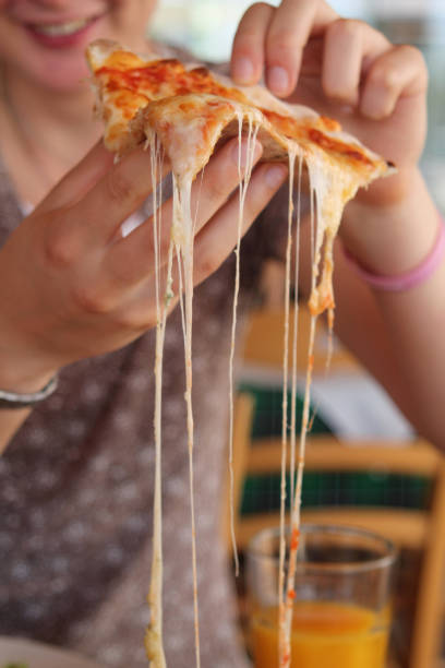 istock Slice of pizza in hands 1151857263
