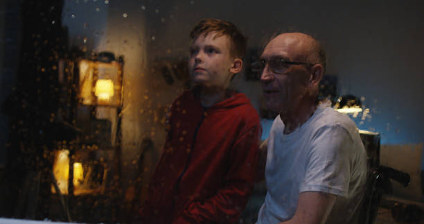 ragazzo che guarda la tempesta con il nonno - lightning house storm rain foto e immagini stock