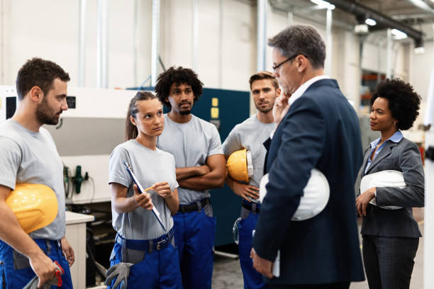 istock Female worker communicating with company leaders while going through reports in industrial plant. 1151861946