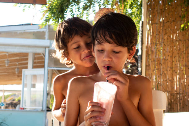 istock Brother Boys drinking milkshake cocktail on beach 1151864565