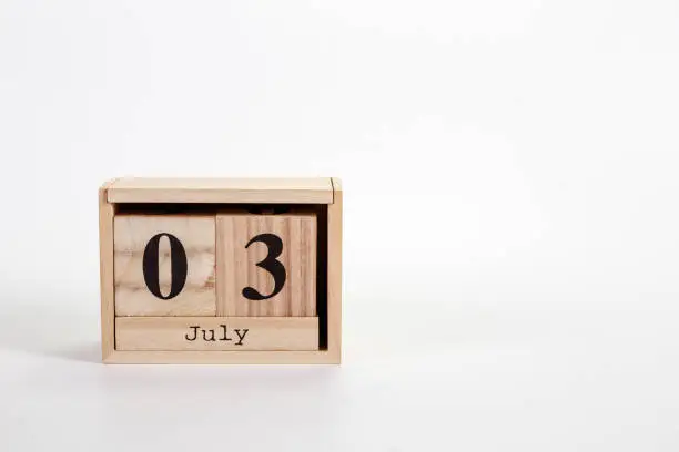 Photo of Wooden calendar July 03 on a white background