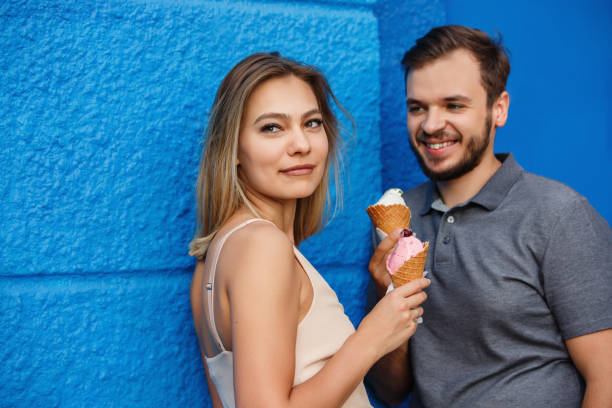 istock Young couple with ice cream on blue wall bckground 1151867042