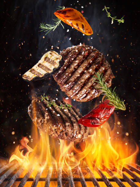 istock Tasty beef steaks flying above cast iron grate with fire flames. 1151868997