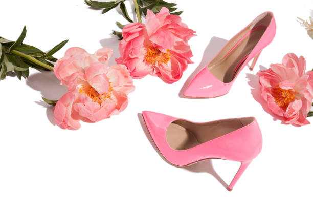 istock Coral pion layout with pink lacquer high heel pumps isolated on white 1151872283