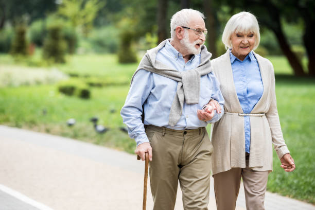 istock happy senior couple talking while walking in park 1151872286