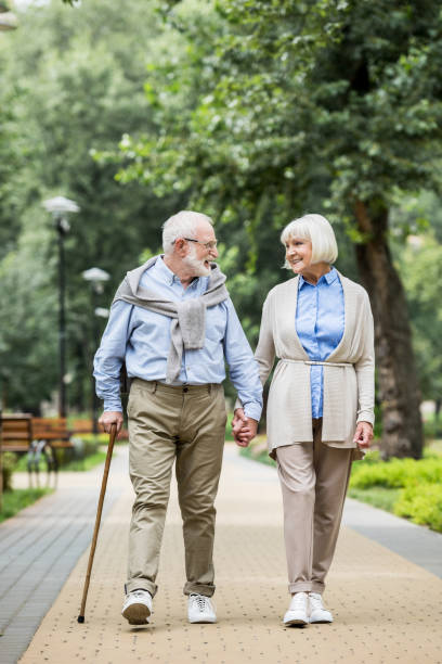 istock smiling senior couple talking while walking in park 1151872319