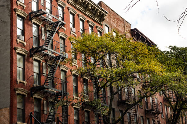 vista ravvicinata dei condomini in stile new york city con scale di emergenza lungo mott street nel quartiere chinatown di manhattan, new york, stati uniti. - queens foto e immagini stock