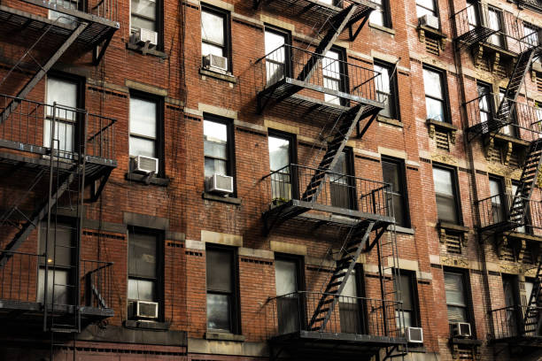 vista de cerca de edificios de apartamentos al estilo de la ciudad de nueva york con escaleras de emergencia a lo largo de la calle mott en el barrio de chinatown de manhattan, nueva york, estados unidos. - the bronx fotografías e imágenes de stock